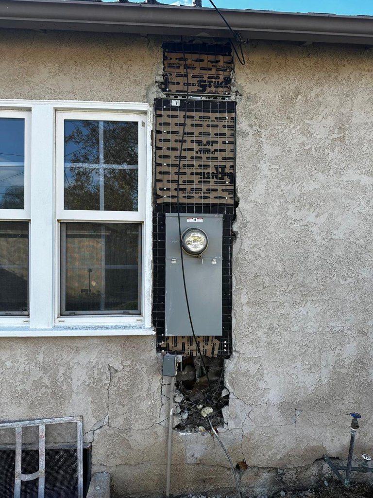 Exterior wall opened for a new service panel installation