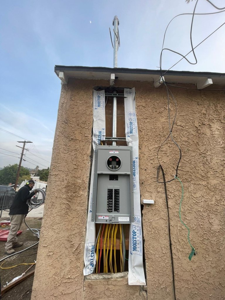 Electrician installing a new exterior service panel